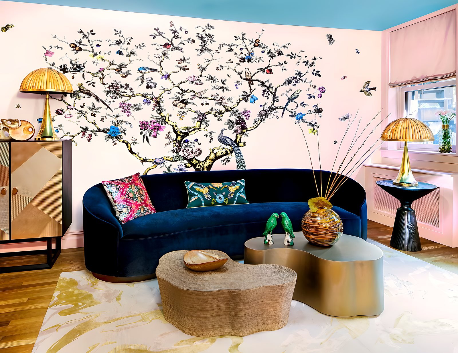 A navy velvet sofa against a hand-painted chinoiserie wall with brass lamps at the Brooklyn Heights Designer Showhouse by Circa22