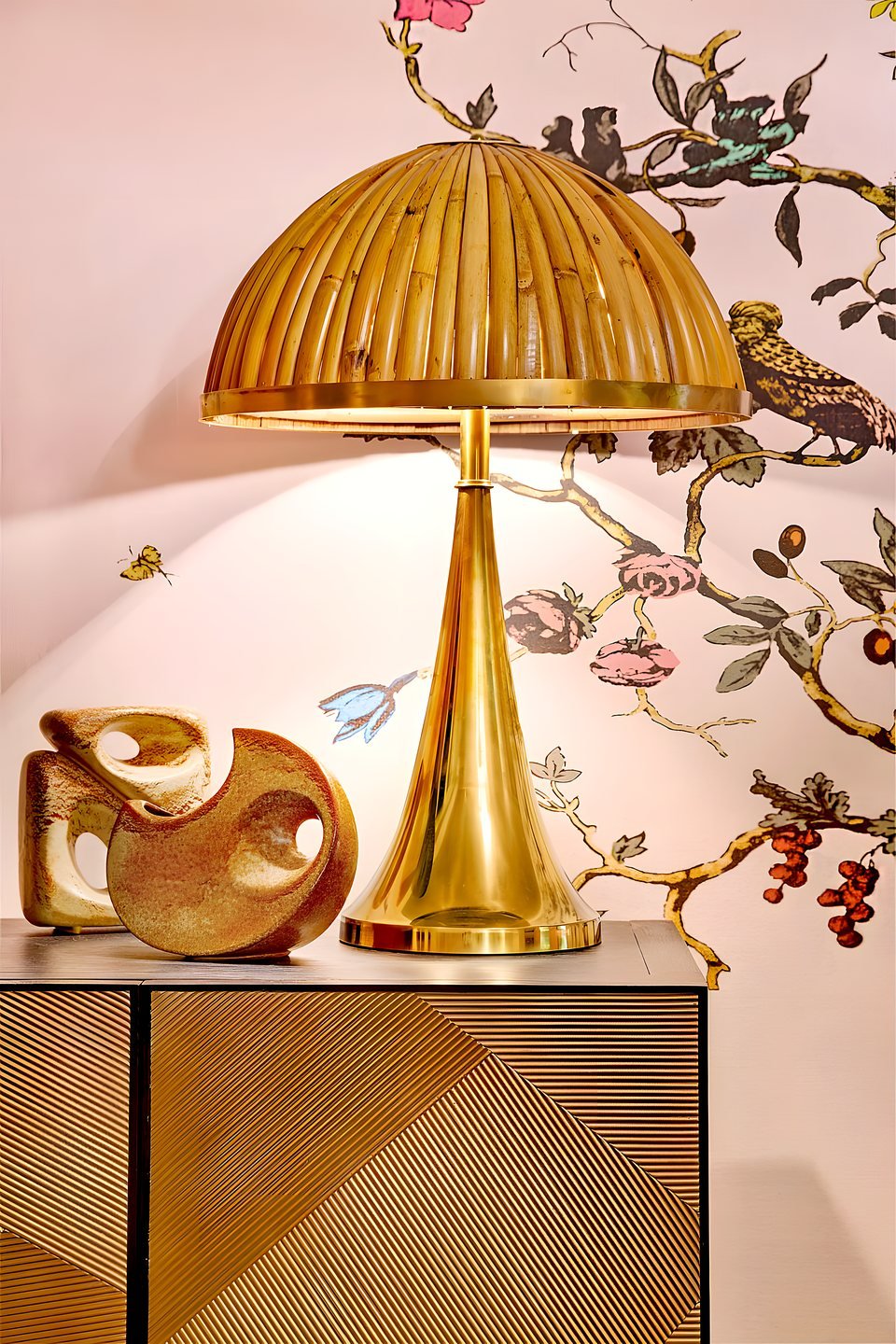 Hand-painted chinoiserie mural wall in soft plaster-pink behind a curved sofa