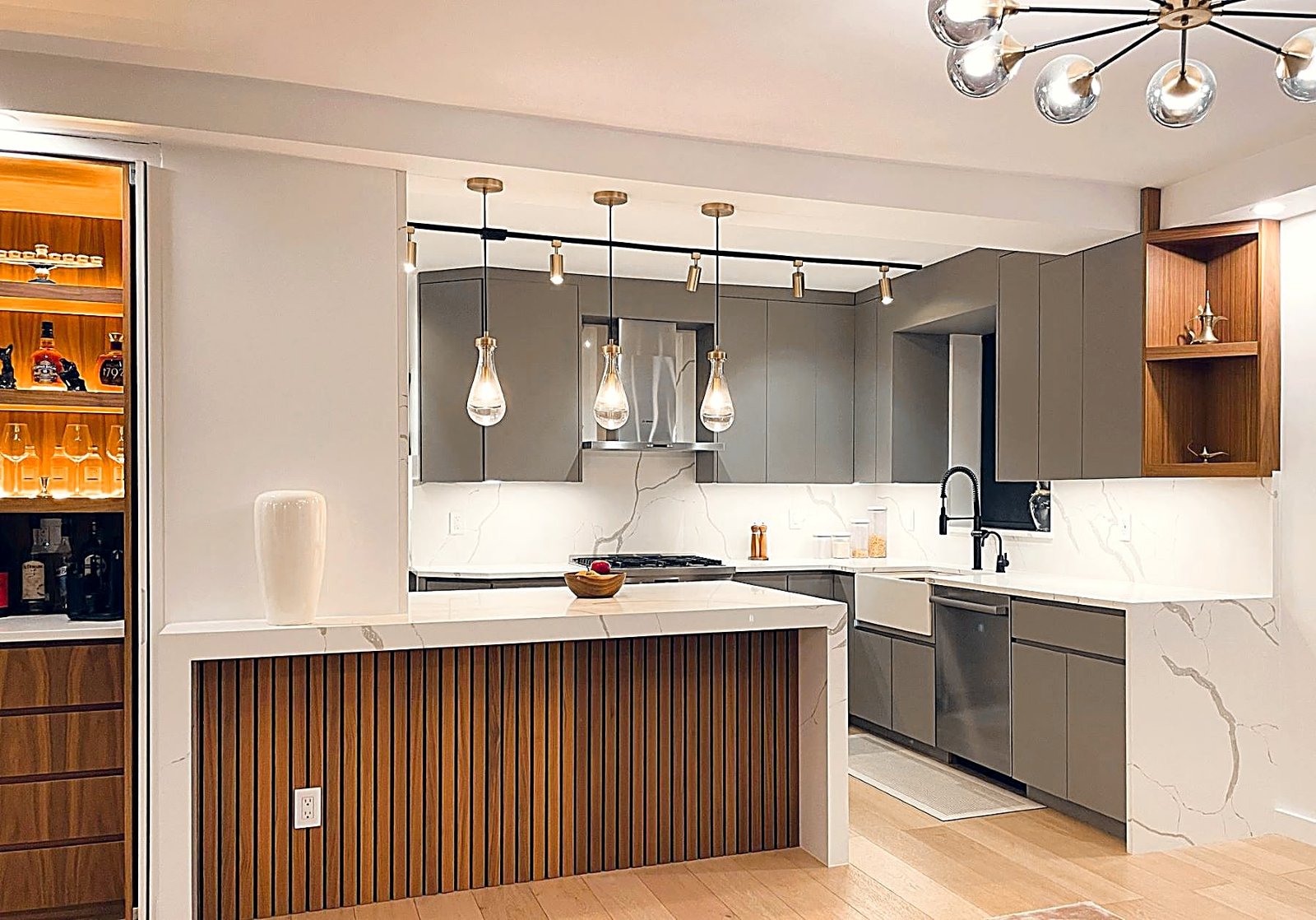 Prewar Upper East Side kitchen with soft grey cabinetry, walnut slat details and a marble waterfall island